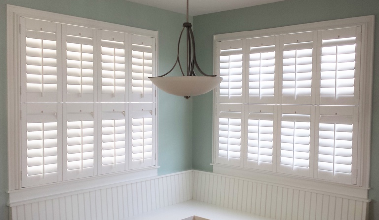 Pastel green wall in Boston kitchen with shutters.